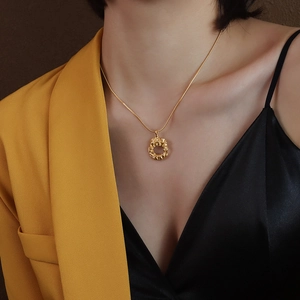 Minimalist 18k gold plated titanium necklace with a round woven texture pendant on a model