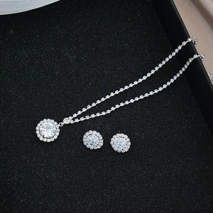 Macro detail of silver necklace and matching stud earrings set with halo pave cubic zirconia