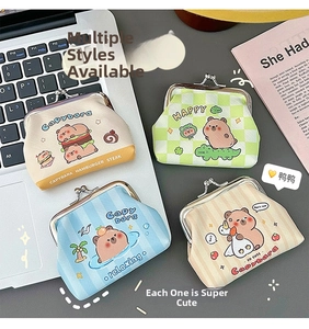Close-up of four Capybara PU leather coin purses with metal clasps on a laptop desk