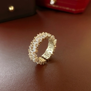 Detailed view of adjustable gold ring with emerald cut and round pave set cubic zirconia