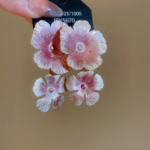 Detailed close-up of pink and white floral earrings with pearlescent petal texture