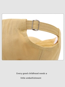 Close-up of adjustable metal buckle and twill cotton texture on khaki kids baseball cap