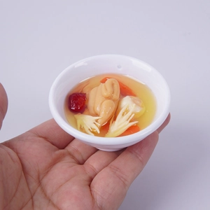 Realistic miniature chicken soup food model keychain with goji berries in a white bowl