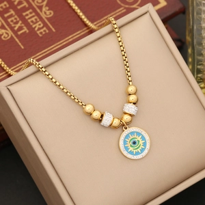 Minimalist stainless steel evil eye necklace with crystals on a beige jewelry box backdrop