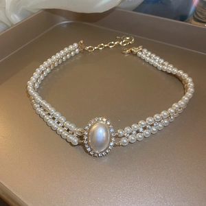 Détail du collier de perles baroques à double rangée avec pendentif strass brillant