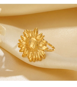 Détail d'une bague tournesol dorée sur un fond élégant en tissu satiné beige chaud
