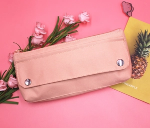 Detail of peach pink oxford fabric pencil case with silver metal snap buttons and zipper