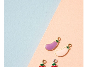 Detail of colorful enamel vegetable charms featuring purple eggplant and red chili pendants