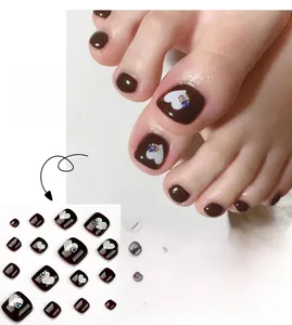 Brown heart press-on toenails with rhinestones and white heart patterns on white background