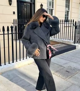Detail of dark gray wool coat featuring plush faux fur collar and elegant wide lapels