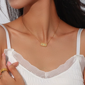 Detailed close-up of gold 11:11 rectangular rhinestone pendant necklace on model