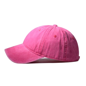 Detail view of rose red washed cotton baseball cap with vintage texture and curved brim