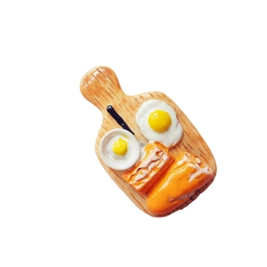 Miniature breakfast resin fridge magnet with toast and fried egg on a wooden tray
