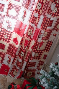 Close-up of Christmas patterned patchwork curtain with heart and stocking embroidery detail