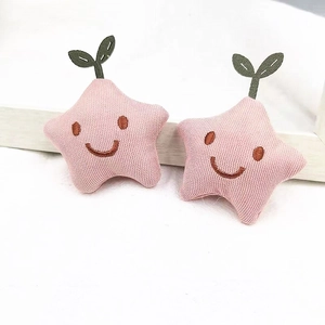 Close-up of pink star-shaped fabric pins with embroidery and green sprout detail