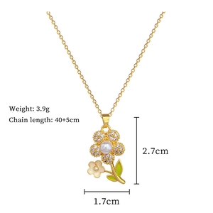 Macro detail of gold flower necklace with white pearls, green enamel, and size specs