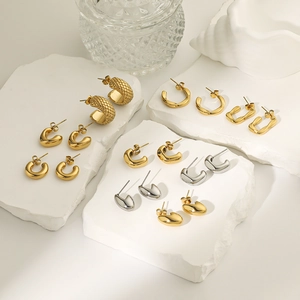 Chic 18K gold and silver geometric C-shape hoop earrings set on modern stone display