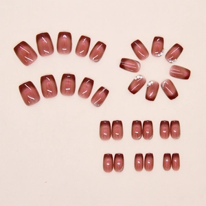 Macro shot of burgundy cat eye press-on nails with pearls and silver glitter details