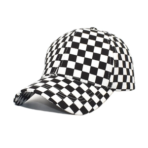 Detailed view of the black and white checkered cow print on a cotton baseball cap