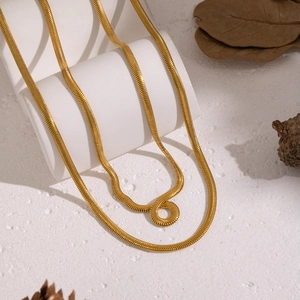 Zweilagige goldene Schlangenkette aus Edelstahl auf einem weißen Sockel-Display