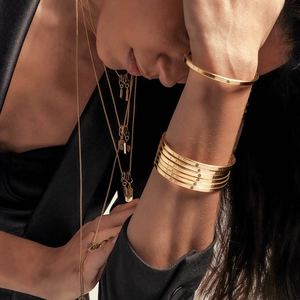 Luxurious gold stainless steel bangle and layered chain necklace set on model