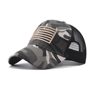 Close-up of camouflage canvas texture and khaki American flag patch on a mesh trucker hat