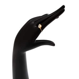 Detail of gold wire wrapped evil eye ring with white bead on a black hand display stand