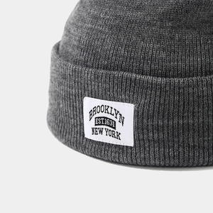 Close-up of dark grey knitted beanie with Brooklyn New York vintage patch detail