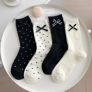 Détail de chaussettes en tricot avec pois, bordure en dentelle et nœuds décoratifs fins