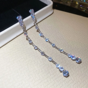 Macro shot of silver drop earrings with tassel zircon chains on a jewelry box