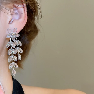 Macro shot of silver tassel earrings with flower leaves and sparkling faceted crystals