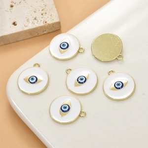 Detailed view of golden evil eye pendants with white enamel and blue eye motifs