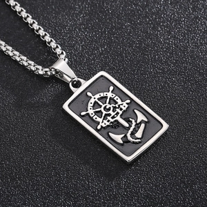 Détail macro du collier hip hop argenté avec pendentif ancre et gouvernail noir