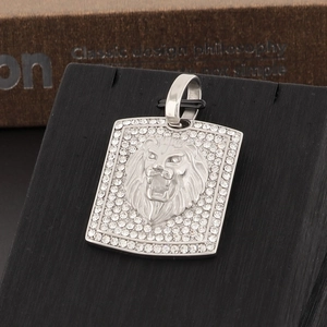 Macro detail of silver lion head pendant with iced-out crystals on black display