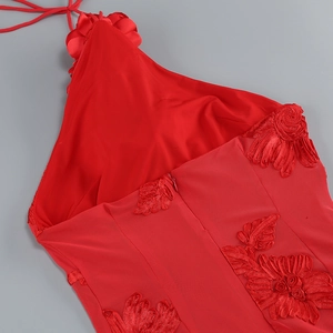 Détail de la broderie florale en 3D sur une robe de soirée rouge dos nu élégante