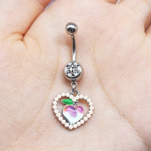 Detail of peach pendant belly ring with heart shape and small pearls around it