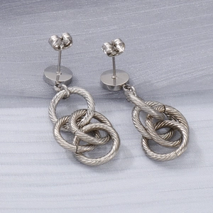 Détail de boucles d'oreilles triple créoles argentées avec texture de câble torsadé