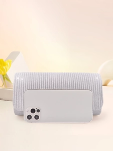 Elegant silver evening clutch bag with vertical texture and smartphone for size reference