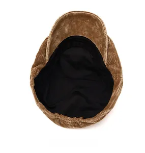 Detail view of the brown corduroy newsboy cap interior showing black lining and elastic band