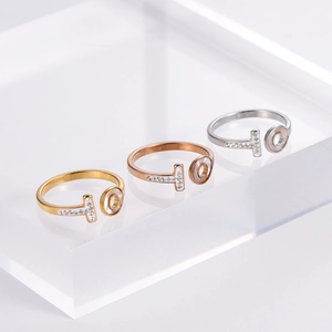 Three minimalist T-shape open rings in gold, rose gold, and silver with shell and zircon