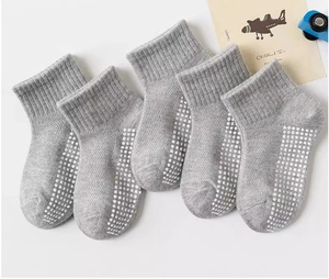 Detail showing non-slip grip dots on grey kids cotton crew socks in 5-pair set