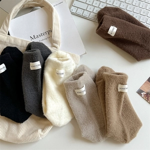 Flat lay of six thick winter socks in earthy tones with small white brand labels