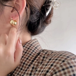 Minimalist gold ball stud earrings for women shown on a model in a French chic style