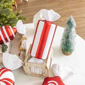 Red and white striped Christmas candy ornaments displayed on a festive tabletop setting