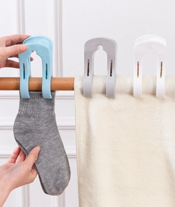 Detail of strong plastic clips holding socks and towels on a wooden bar for drying