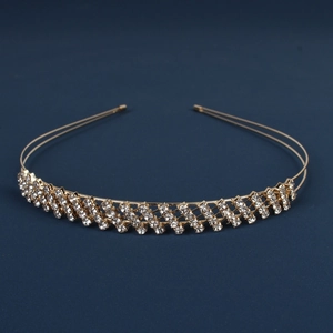 Detail of a golden double-strand woven headband with sparkling rhinestones on blue background