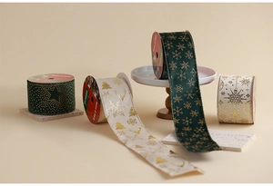 Close-up of gold-stamped Christmas ribbons with reindeer and snowflake patterns
