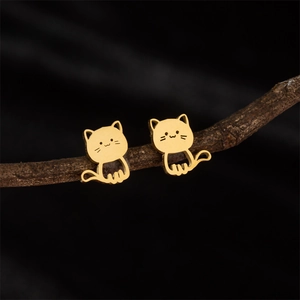 Cute golden stainless steel cartoon cat stud earrings displayed on a natural branch