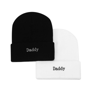 Détail de la broderie Daddy sur des bonnets en maille noir et blanc de style minimaliste