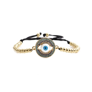 Adjustable woven Evil Eye bracelet with gold beads and blue zircon crystals in a minimalist style